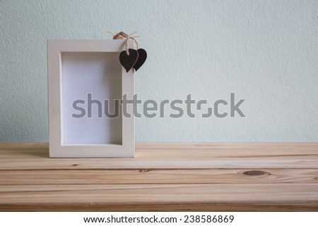 White photo frame on wooden table over grunge background, Valentine concept