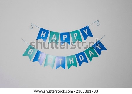 Happy Birthday triangle flag garlands decorate on wall background.