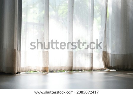 wooden counter table top on the window background with white curtains can see a blurry garden of trees. of spring. Ideas for designing key image layouts and editing product displays and space empty