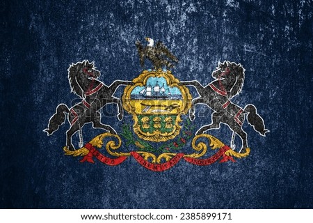 Close-up of the grunge Pennsylvania state flag. Dirty Pennsylvania state flag on a metal surface.