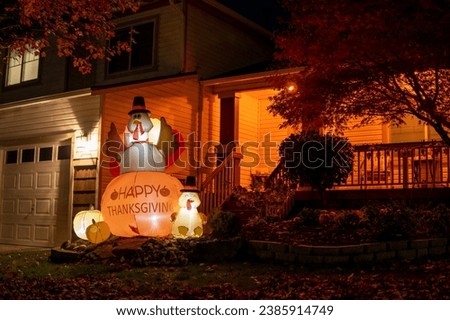Glowing outdoor inflatable turkeys figures in the hat with inscription - Happy Thanksgiving in the front yard Royalty-Free Stock Photo #2385914749