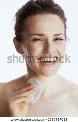 Portrait of smiling middle aged woman with cotton pad isolated on white. Royalty-Free Stock Photo #2385917013