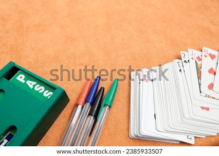 Playing cards and boxes for playing bridge. Gambling, bridge, poker concept. Sport equipment.Orange background.
