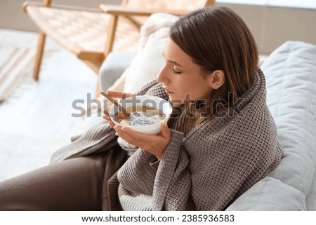 Ill young woman eating chicken soup at home, closeup Royalty-Free Stock Photo #2385936583