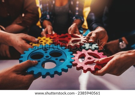 Business team work together and combine pieces of gears. Partnership and integration concept Royalty-Free Stock Photo #2385940561