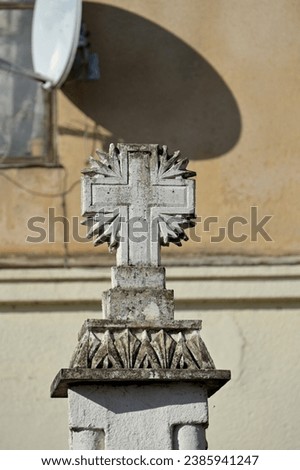 a massive concrete cross on a rectangular pillar