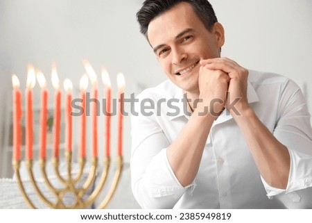 Young man celebrating Hanukkah at home