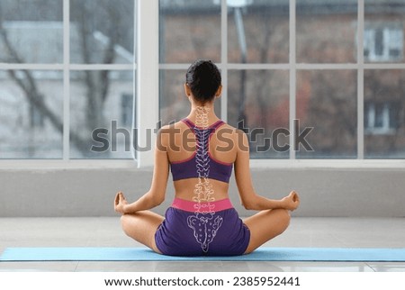 Sporty young woman practicing yoga in gym. Concept of healthy spine Royalty-Free Stock Photo #2385952441