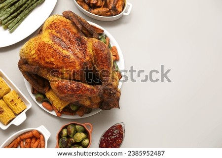 Plate with tasty roasted turkey and different dishes for Thanksgiving day on white background Royalty-Free Stock Photo #2385952487