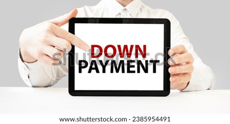 Text DOWN PAYMENT on tablet display in businessman hands on the white background. Business concept