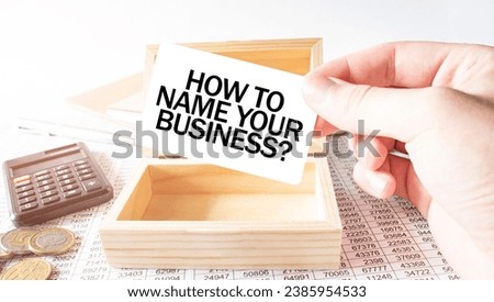 Businessman hold white card with text HOW TO NAME YOUR BUISINESS Calculator, wood box, money and financial documents