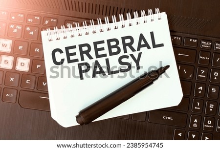 White paper sheet with text CEREBRAL PALSY on the black laptop