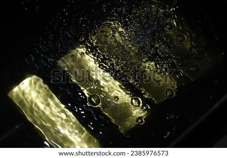Ingots of 99.99 percent pure gold in the water at a precious metals refining plant in Russia. Royalty-Free Stock Photo #2385976573