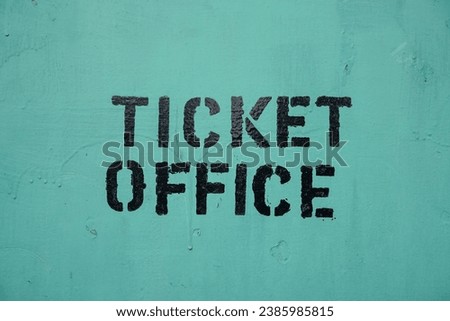 Painted Ticket Office sign on green background. 
