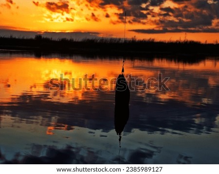 Fishing at sunset. Catching predatory fish on spinning. Sunset colors on the water surface, sunny path from the low sun. Perch caught on yellow spoonbait Royalty-Free Stock Photo #2385989127