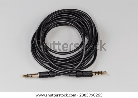 Rolled up analog audio cable with gold-plated stereo connectors mini jack on the edges on a gray surface
 Royalty-Free Stock Photo #2385990265