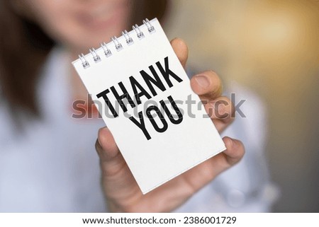Close-up of woman holding a sticky note with text Thank You a smiley face
