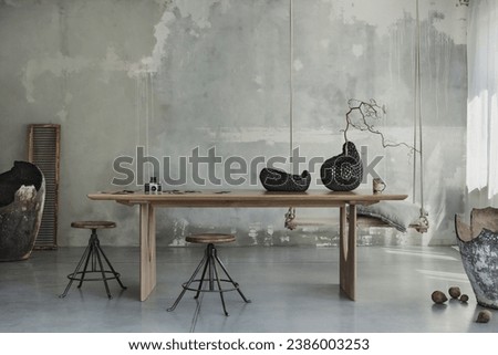 Minimalist composition of japandi dining room interior with wooden table, concrete wall, round stool, stylish vase with branch and personal accessories. Home decor. Template. Royalty-Free Stock Photo #2386003253