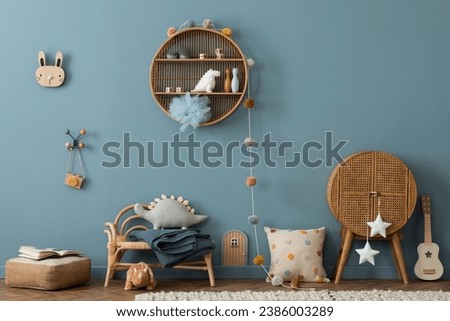 Creative composition of kids room interior with blue wall, rattan sideboard, armchair, pillows, guitar, round shelf, plush toys, plaid, rug books and personal accessories. Home decor. Template.