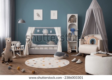  Interior design of cozy child room interior with bed, stylish rack, armchair, blue wall, round rug, colorful toys, guitar, books, mock up paintings and personal accessories. Home decor. Template.