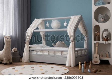 Warm and cozy child room interior with cozy bed, plush lama, white decorations, round rug, blue wall, gray box, guitar, pillows, garland and personal accessories. Home decor. Template.