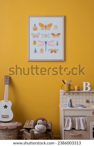 Warm and cozy composition of child room interior with mock up poster frame, children kitchen, braided bench, basket, guitar, bear carpet, wooden blocks and personal accessories. Home decor. Template.