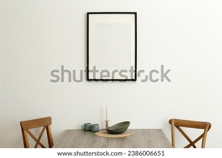 Room interior with dining table, wooden chairs and photo frame