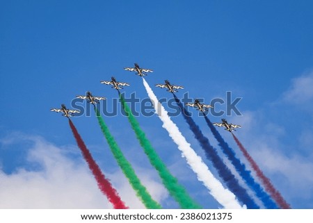 Three colored demo team show passing by with blue sky and clouds Royalty-Free Stock Photo #2386021375