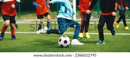 Children playing football game on a school tournament. Dynamic, action picture of kids competition during playing footbal. Football soccer match for children. 