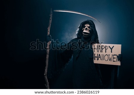 The scary grim reaper is holding a sign happy halloween poster . Death with poster. Skeleton, skull, silhouette of a man in a black robe depicting death. Halloween characters concept.