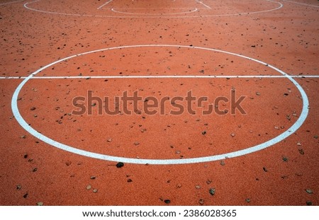 Basketball court in autumn with fallen leaves on it. Seasonal sport background.        