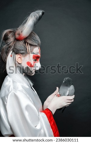 Beautiful actress woman with stage makeup, mask and costume on black background. Halloween, carnival, performance and theater concept