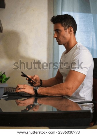 Photo of a man working on a laptop at a desk