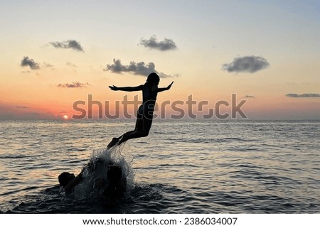 Summer vacation, travel and holiday concept. Family having fun on sea beach outdoors. Child girl jumping