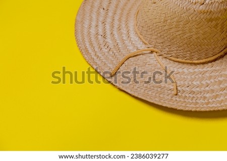 Straw hat on yellow background with summer theme. Space for text. Hat concept. Sombrero concept.
