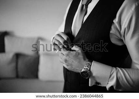 A young business man is getting dressed for a meeting.