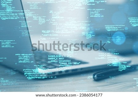 Close up of laptop computer on desk with supplies and creative coding html language on blurry background. Web developer and programming concept. Double exposure