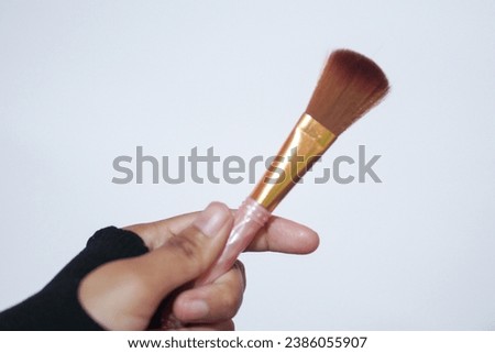 Hand model holding a a set of makeup brushes with a white background for cosmetic advertising