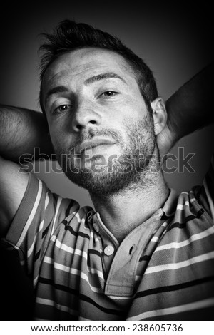 Portrait of a relaxed man with hands behind his head. Black and white style picture.