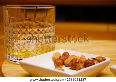 Cigar whiskey chocolate and nuts on wooden table close up view