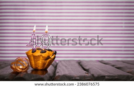 Birthday number 49. Date of birth with number of candles, copy space. Anniversary background with cake or muffin with burning candles. Greeting card.