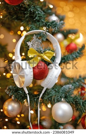 Headsets play Christmas songs and new music playlist on the Christmas tree. Royalty-Free Stock Photo #2386081049