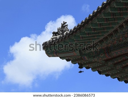 Low angle view of wind chime and Dancheong on the eaves of Daeungjeon Hall with dragon sculpture on the roof at Jogyesa Temple of Jongno-gu, Seoul, South Korea
