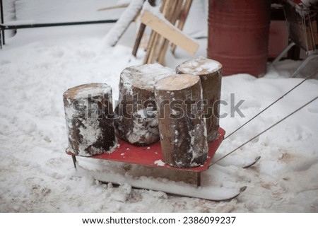 Logs on a sleigh. Logs for splitting with an axe. Transportation of dry fuel. Life in the countryside in winter.