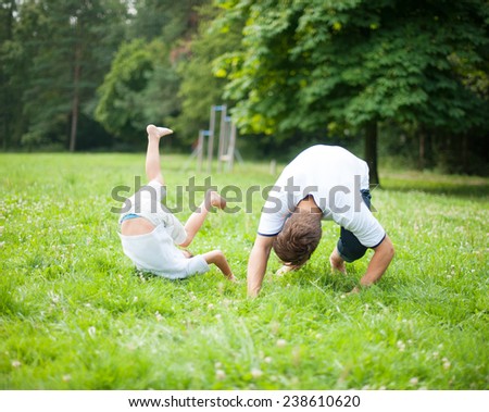Father and son somersaulting on the ground Royalty-Free Stock Photo #238610620