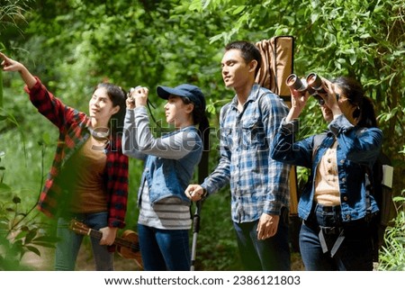 Group of friends walking on an adventure in the forest Look at the map to explore the forest and plan as a team.