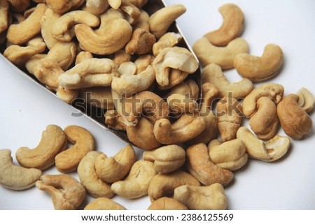 Close-up of roasted cashew nuts (Anacardium occidentale) on a white background. View from above. Native of Brazil. Rich in magnesium, iron, zinc, selenium, vitamin A, E and antioxidants.