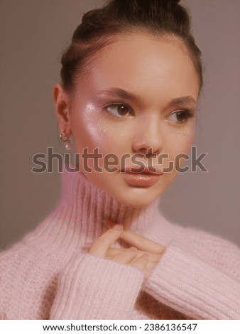 Stylish female model in bright colorful lights posing in studio. Portrait of a beautiful girl with fashionable shining makeup. Beautiful jewelry and accessories. Neon color.