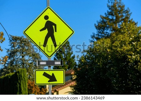 Pedestrian crossing sign with flashing lights. Crosswalk beacon provides advance notice of pedestrian activity for drivers.