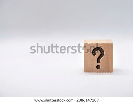 Question mark on wooden cube on white background.